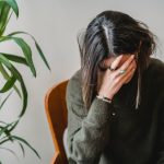 worried young woman covering face with hand