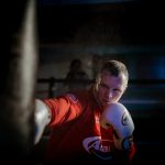 boxer hitting punching bag in boxing ring